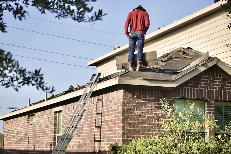Professional roofer working on a residential roof in Duclay